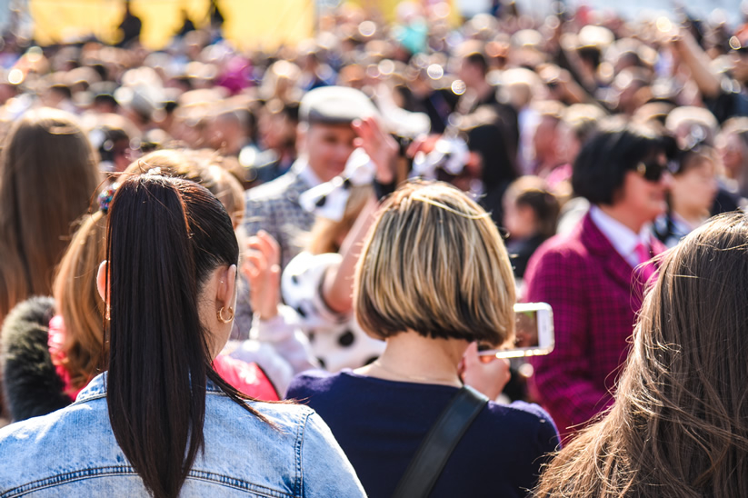 Crowds on college campus - female student looking at phone