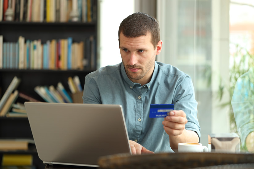Man paying rent via computer with credit card